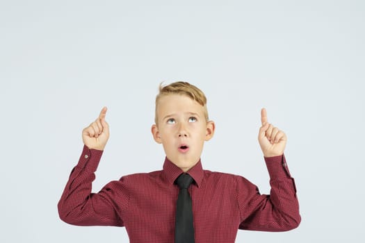 A portrait of a schoolboy showing thumbs up.