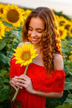 Cute young woman is holding sunflower in her hand while