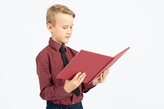 Pupil holds an open book in his hands and reads, isolated background.