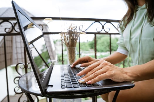 Young woman working at laptop on the terrace