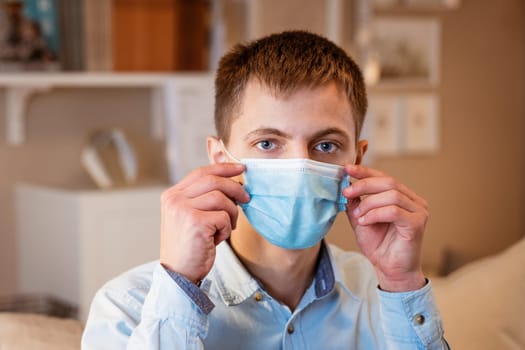 young guy sitting on the couch wearing a medical mask