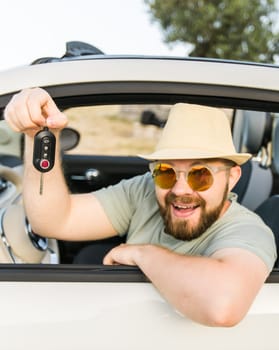 Handsome happy man showing key of new car - Rental and buy new car