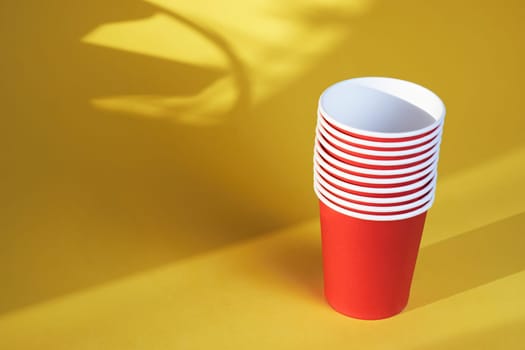 bright red disposable cups on a yellow background disposable tableware