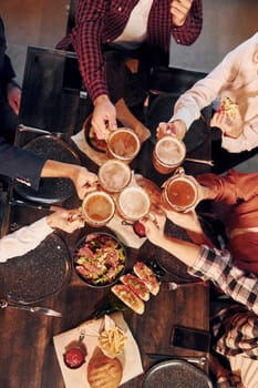 Cheerful emotions. Group of young friends sitting together in bar with beer