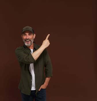 Advertising concept, mature European caucasian man pointing his finger to side. Hunter advertising concepts, marketing strategies, business communication scenario.