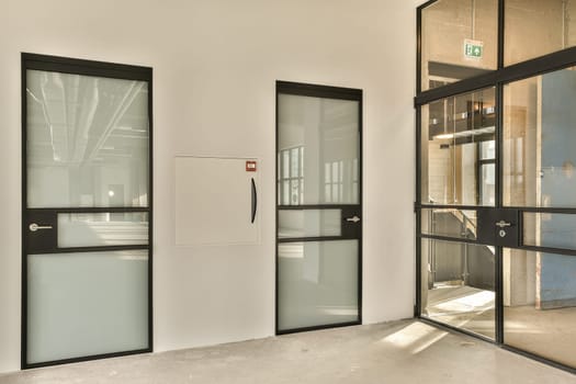 a lobby with glass doors and a white wall