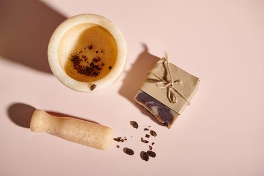 Top view marble mortar, pestle and homemade soap with coffee beans. Natural organic cosmetics for body and skin care