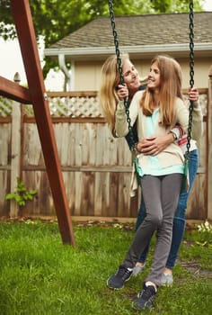 Keeping their bond strong. a mother and her daughter playing on a swing in their backyard.