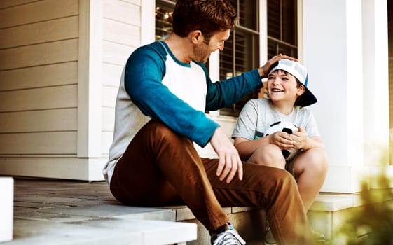 Fatherhood is what taught me the true meaning of love. a father and his son bonding on their porch at home.