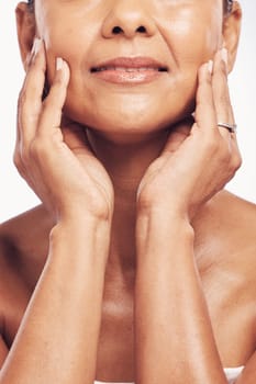 Hands, mouth and skincare with a mature woman in studio for beauty, anti aging treatment or cosmetics. Skin, facial and wellness with a senior female touching her smooth face for hydration closeup