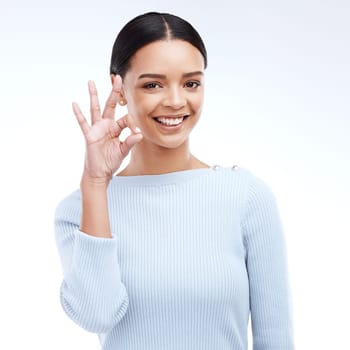 Portrait, yes and hand sign by woman in studio for okay, perfect and positive review on white background. Face, ok and girl with emoji hand for success, vote and support or approval while isolated