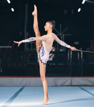 Ribbon, gymnastics and flexible woman in dance performance, balance legs and sports competition. Female, rhythmic movement and flexible dancing athlete, action and talent of creative concert in arena