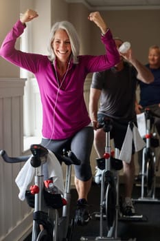 Yes I did it. a group of seniors having a spinning class at the gym.