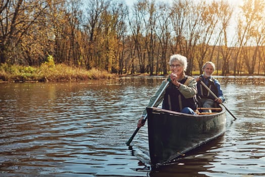Hes her hubby and canoeing buddy. a senior couple going for a canoe ride on the lake.