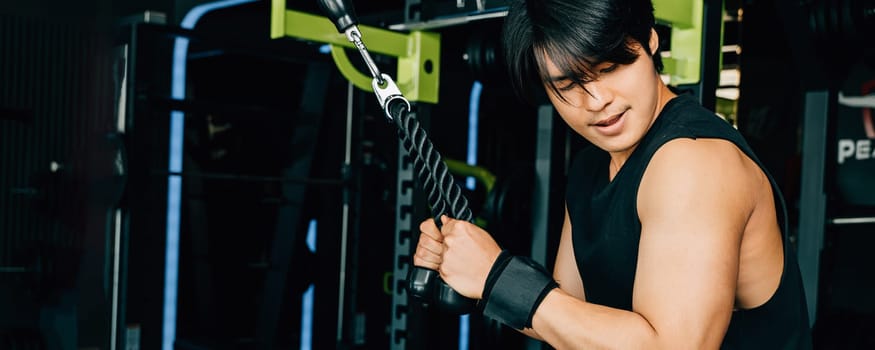 Young man performing cable triceps pulldowns to build muscle and strength