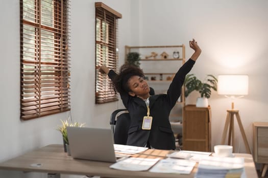 Black business woman stretches in office at workplace