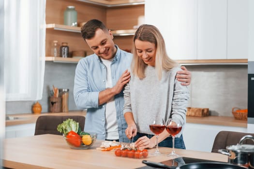 Cute people. Couple preparing food at home on the modern kitchen