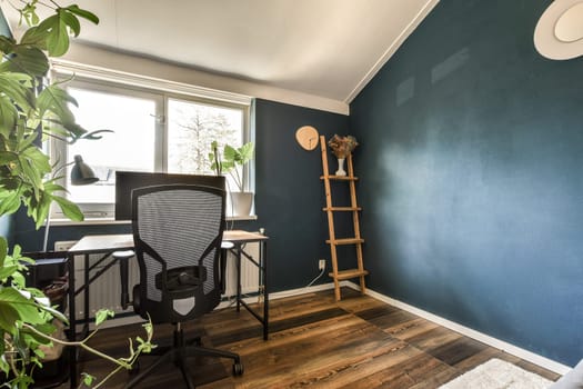 a home office with a chair and a blue wall