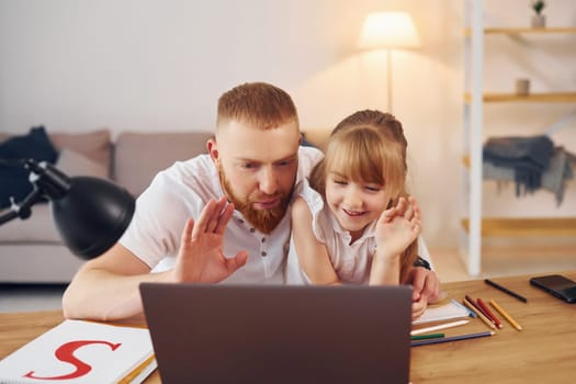 Online learning. Father with his little daughter is at home together