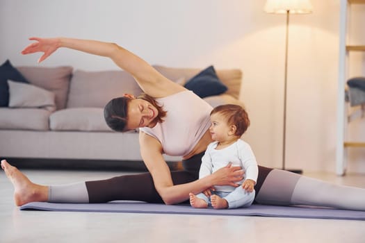 Teaching fitness. Mother with her little daughter is at home together
