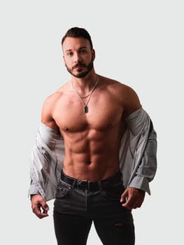 Handsome young muscular man taking off shirt