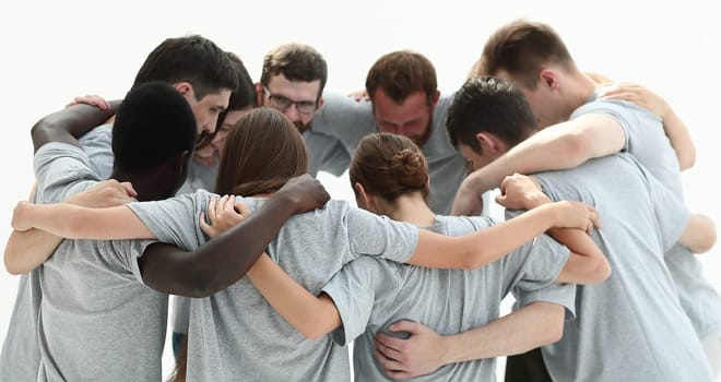 group of young people standing in a circle and hugging each othe
