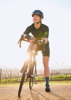 Rest, cycling and fitness with woman in nature for training, workout and sports cardio. Health, relax and thinking with female cyclist riding on bike in outdoor for exercise, endurance and challenge