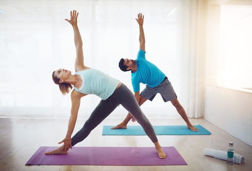 Yoga has the potential to transform your relationship. a couple practising yoga at home.