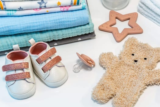 Baby clothes and accessories on a white table. Concept of newborn baby