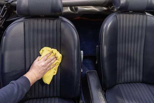 manual cleaning of the leather in the interior of the car with a micro towel