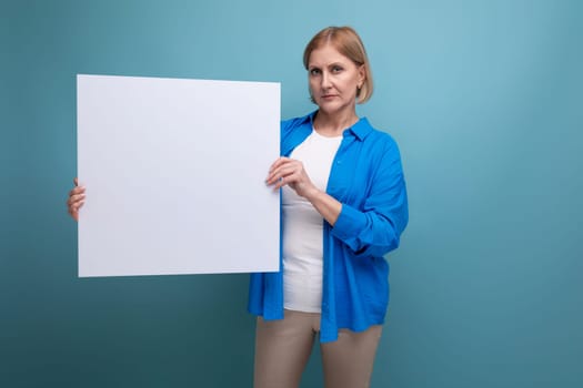 middle age business concept. mature woman with blank paper on blue background copy space