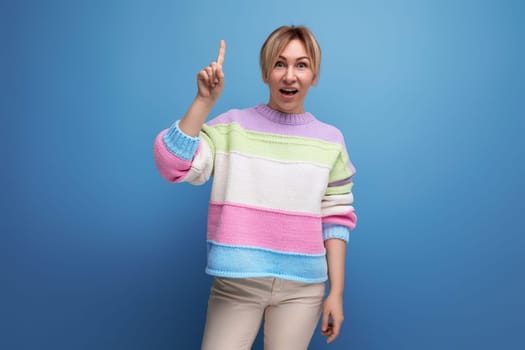 portrait of surprised blond woman in casual outfit on blue background with copy space
