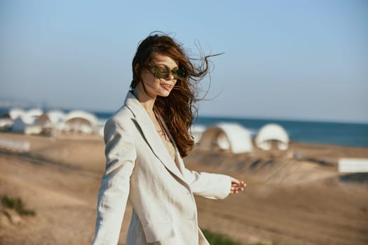portrait of a woman in a light jacket and black glasses on the background of the sea