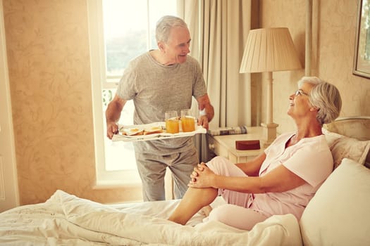Starting the day off perfectly. a senior man bringing breakfast in bed to his wife.