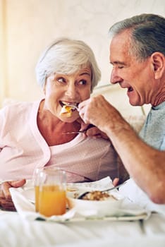 Ive always loved your silly streak. a senior couple having breakfast in bed together.