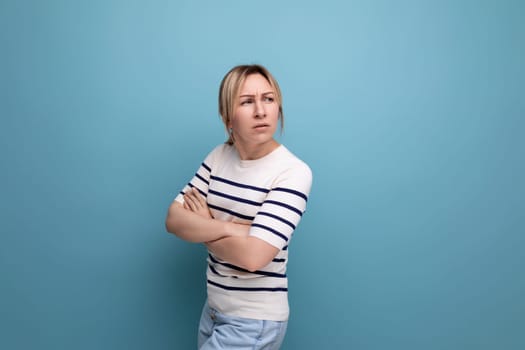 serious sullen blond girl on a blue background with copyspace