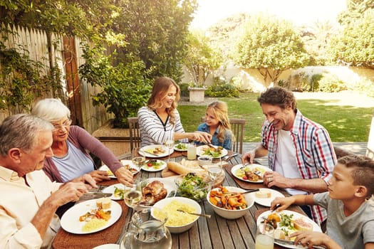 When you share food, you share happiness. a family eating lunch together outdoors.