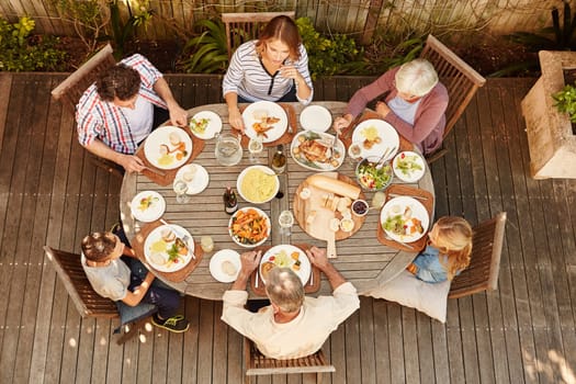 The perfect way to spend family time. High angle shot of a family eating lunch outdoors.