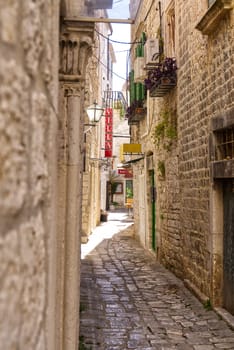 Narrow street with stone houses. Old houses and old narrow alley in Trogir, Croatia, Europe