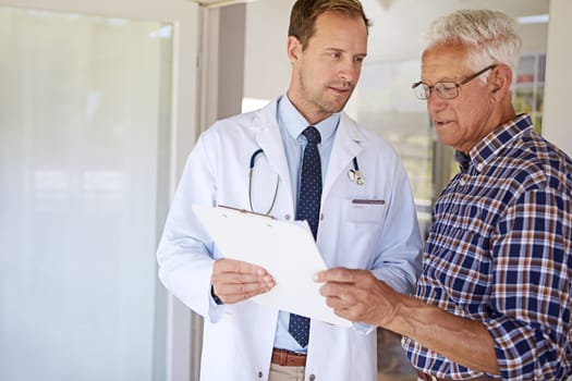 Theres a few things we need to discuss. a male doctor talking to a senior patient in the retirement home.