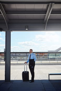 Not a rental car in sight. a professional businessman waiting for transportation outside an airport.