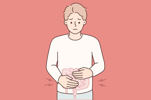 Man puts hands on stomach feeling pain in intestinal due to malnutrition or fast food poisoning
