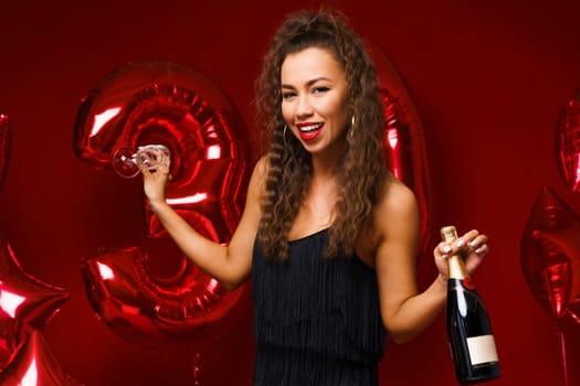Beautiful woman posing on a red background with balloons
