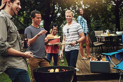 Weekends are all about grilling and chilling. a group of friends having a barbecue in the yard.