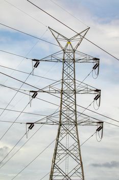 Image of high voltage electricity pylon and transmission power line with sky background.