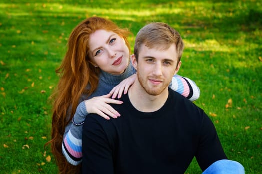 Cheerful young couple in the park on the grass