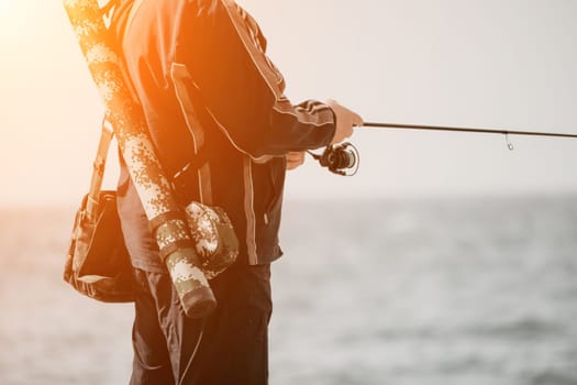 Man hobby fishing on sea tightens a fishing line reel of fish summer. Calm surface sea. Close-up of a fisherman hands twist reel with fishing line on a rod. Fishing in the sea outdoors. Slow motion.