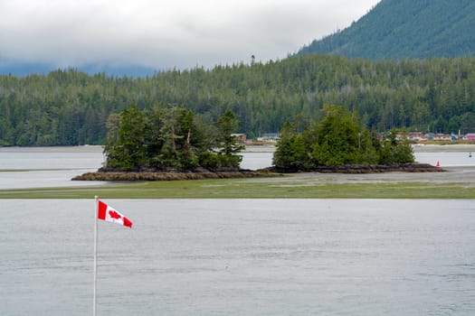 Canadian flag on Pacific ocean shore on Vancouver island