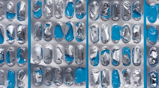 Empty blister pack of capsules on a blue background, close up