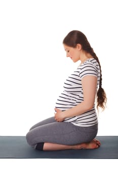 Pregnant woman doing yoga asana Virasana